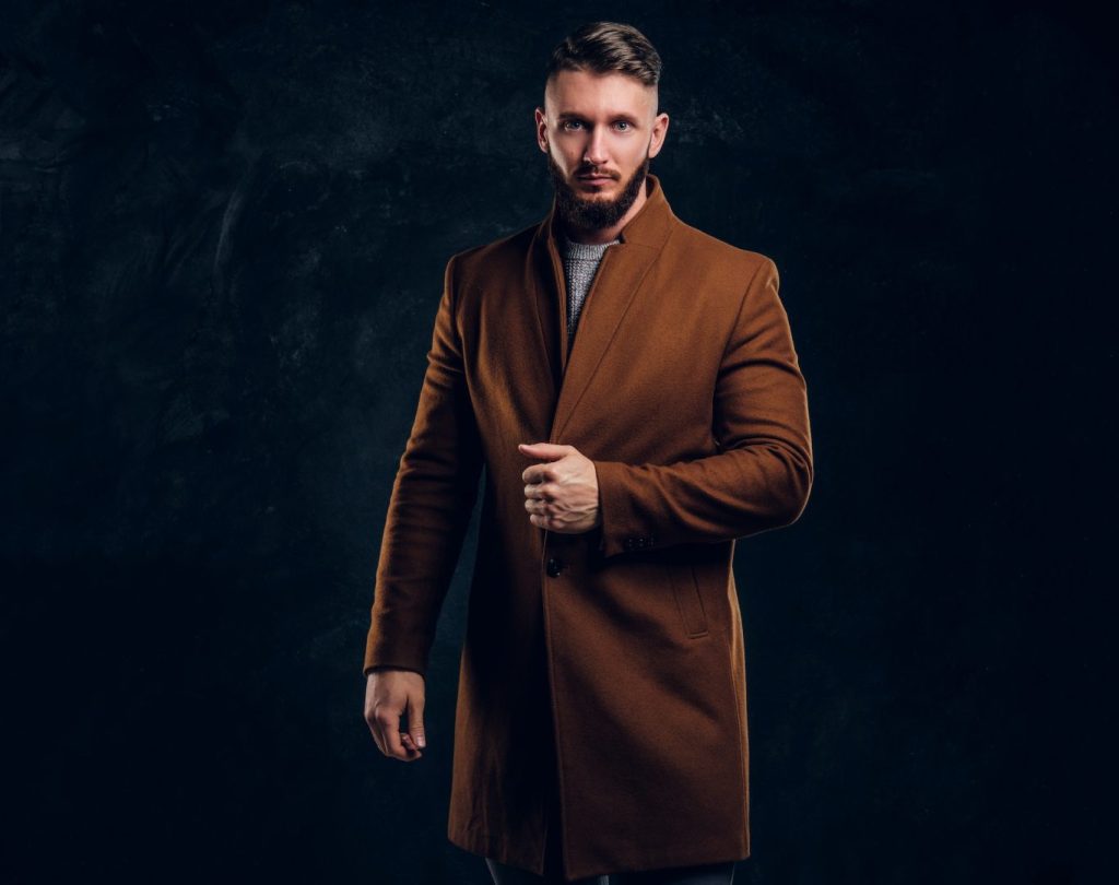 Portrait of a stylish male wearing the demi-season coat. Men's beauty, seasonal fashion